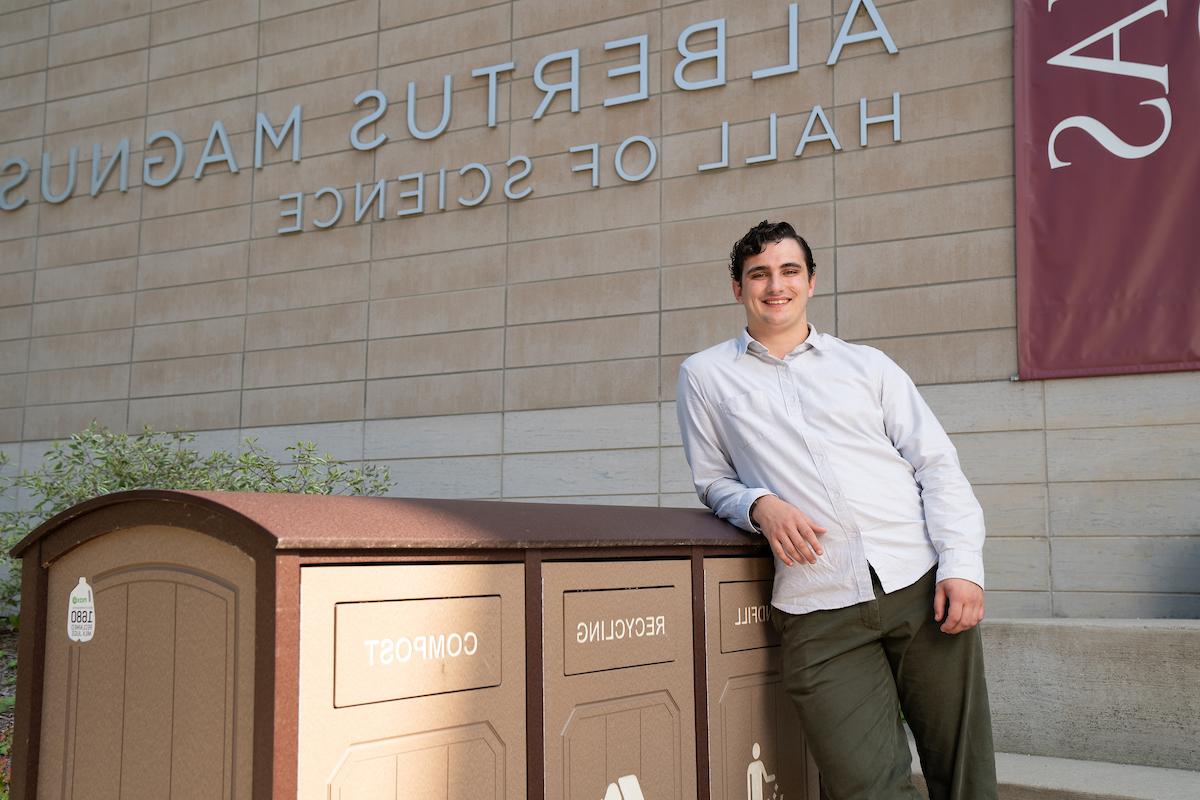 援助an 唐纳利 beside waste collection bins outside of Albertus Magnus Hall of Science