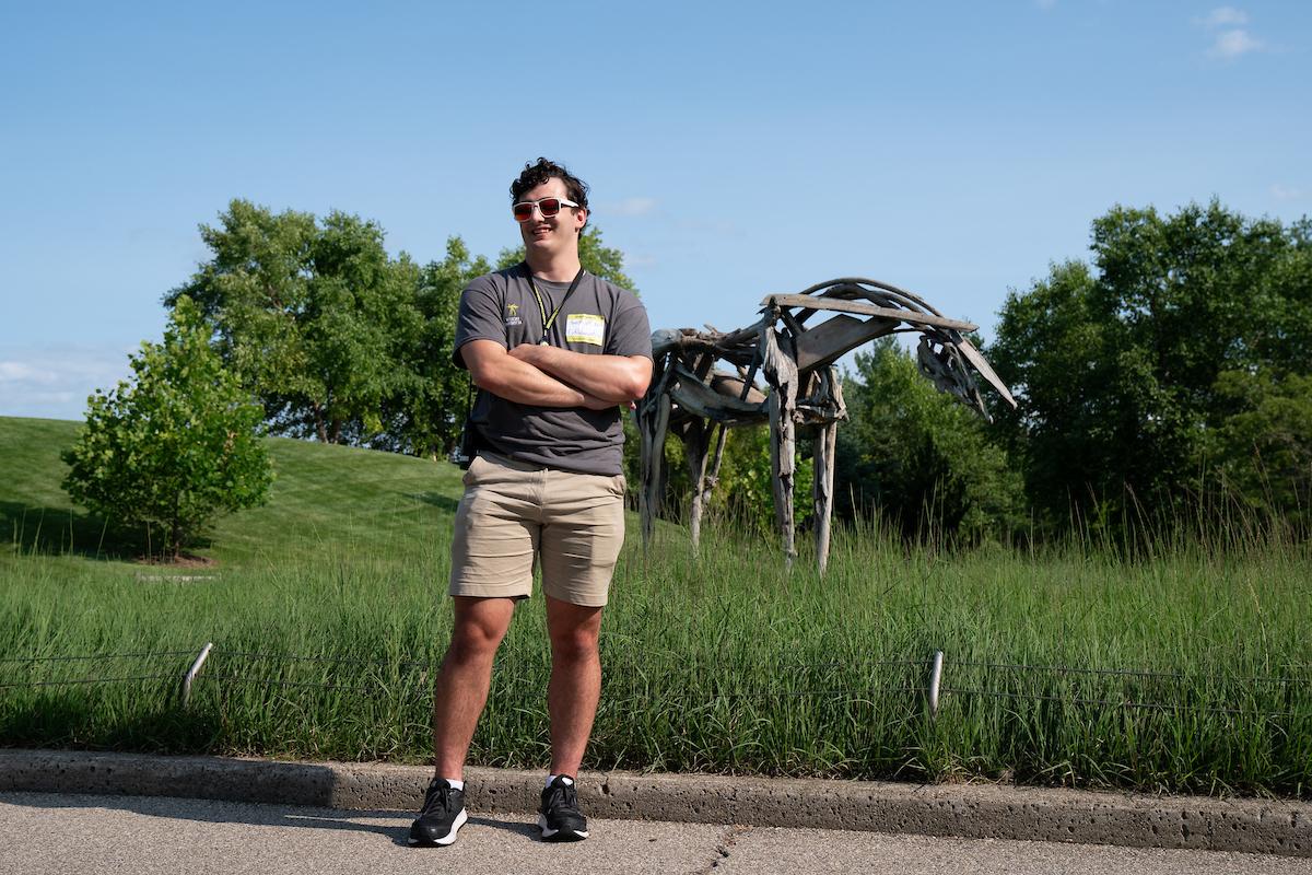 唐纳利 in front of a sculpture of a horse made of bronze casted driftwood called Cabin Creek